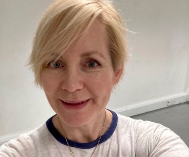 A selfie of Polly Wiseman smiling - they have short blonde hair and wear a white tshirt