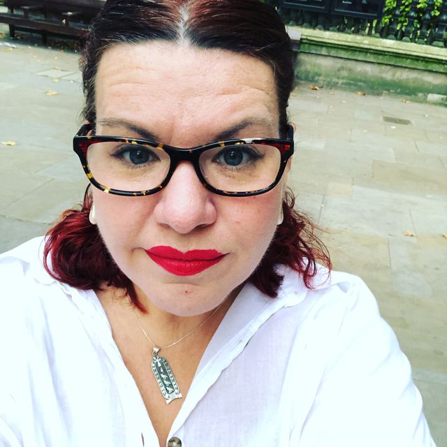 Headshot of Emma, a white women with auburn hair wearing glasses and a white shirt