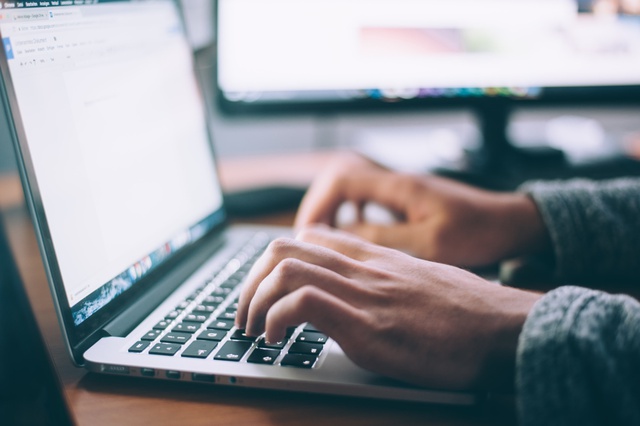 Side view of a laptop with someone typing